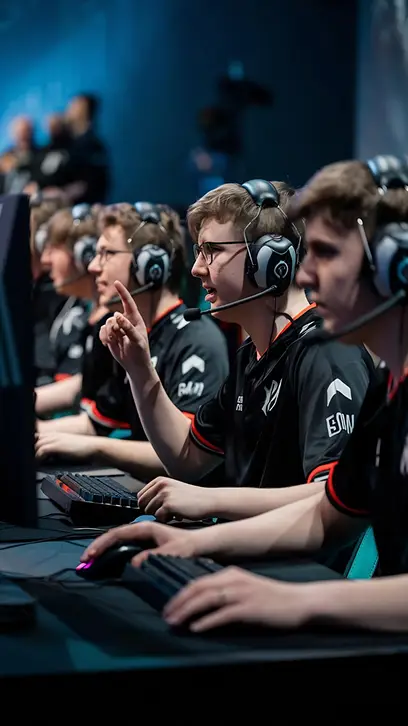 Een esports-team viert zijn overwinning terwijl het op pc’s met headsets speelt, en toont daarbij enthousiasme en teamwork tijdens een competitieve gamingwedstrijd